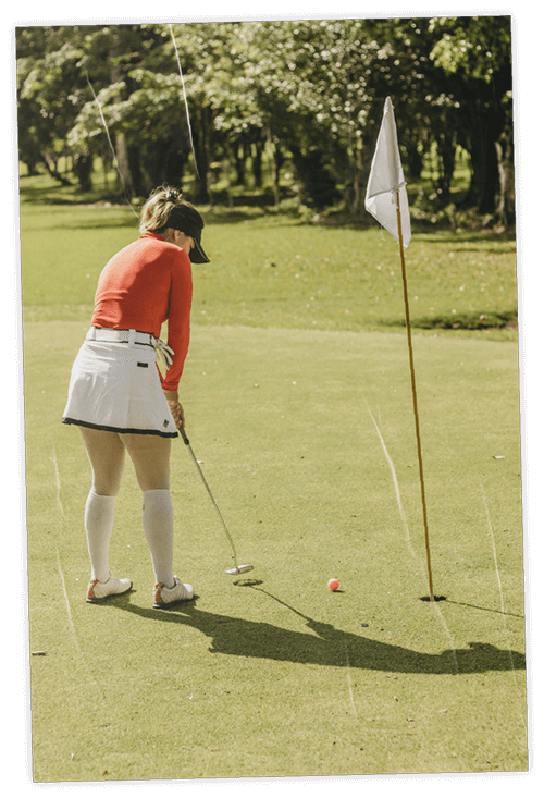 Woman on lush golf course putting on the green
