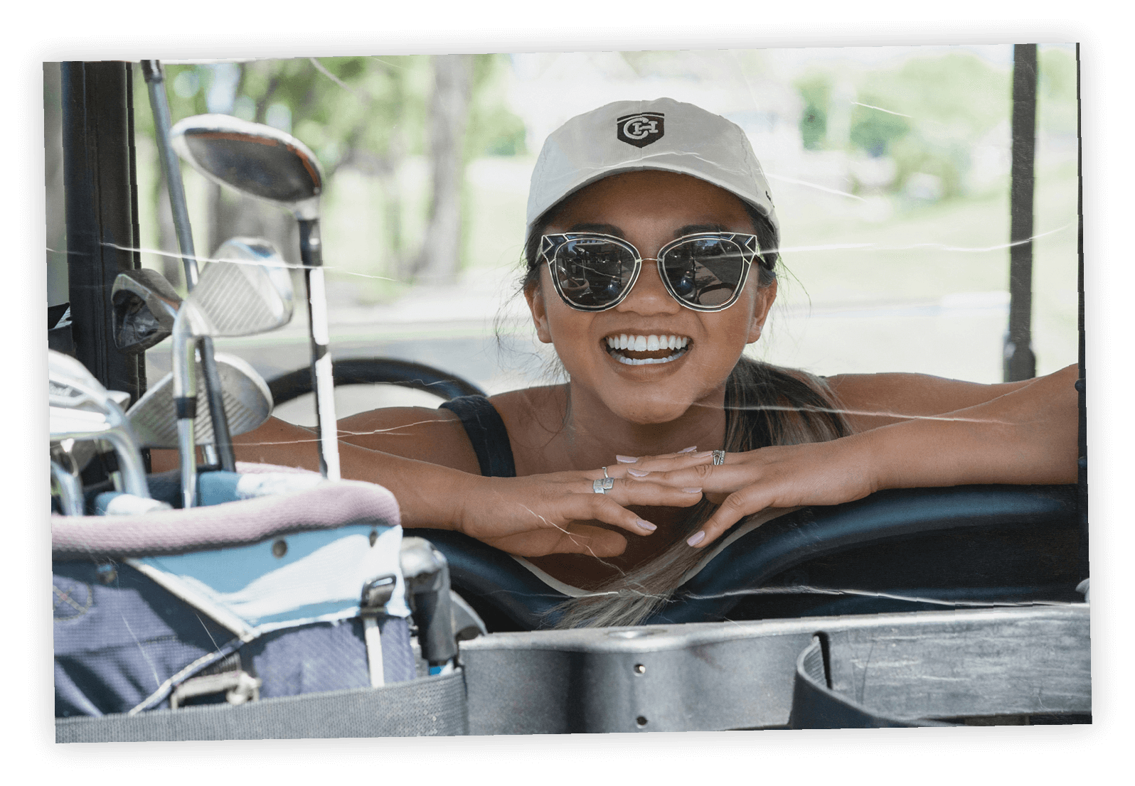 Smiling woman in sunglasses on a golf cart